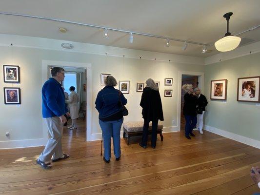 Visitors admiring artwork and checking out artworks in progress at the studio in the back