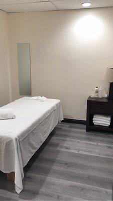 Very clean massage room with neat towels and massage table coverings.