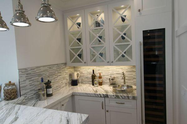 Custom cabinets in bar area, calcutta black countertops and mosaic backsplash