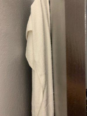 A used towel hanging on back of door upon arrival