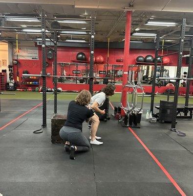 Dr. Morgan working on squat form with a client at our Optimize Your Squat Workshop in May.