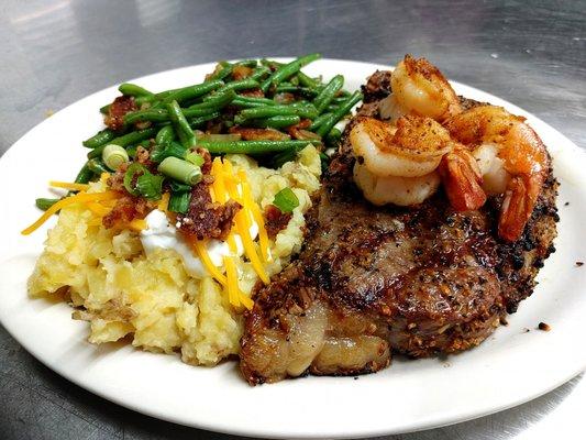 12oz ribeye served with grilled shrimp, loaded mashed potatoes and brown sugar bacon green beans