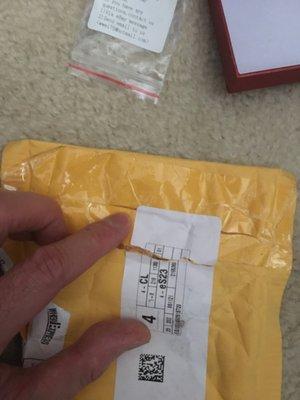 As you can see someone slit the package with a sharp razor and applied tape to the package. Then applied the third party shipper mark label