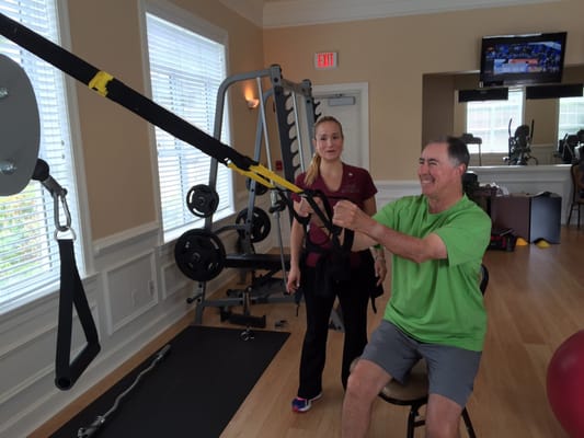 Charity training her client on a TRX system.