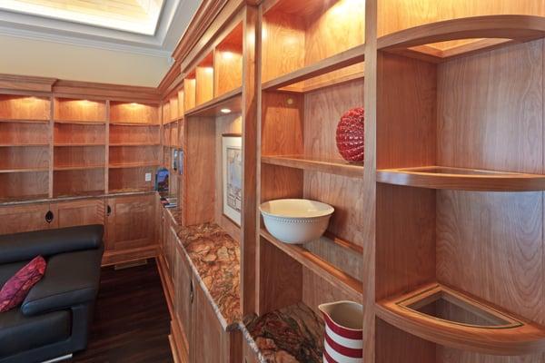 Custom red birch framed class shelves, lighting from above with granite countertops