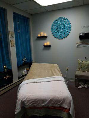 Massage bed in the room. LED candles surround the bed with calming music and scents being diffused during the session.