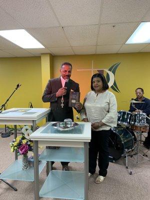 Pastor gives a Bible to Rita after baptism