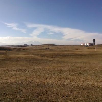 Gorgeous driving range facing an airport and the Flatirons