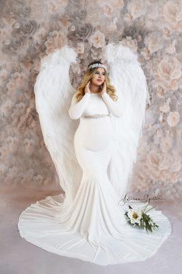 Maternity photo in studio with white gown and angel wings