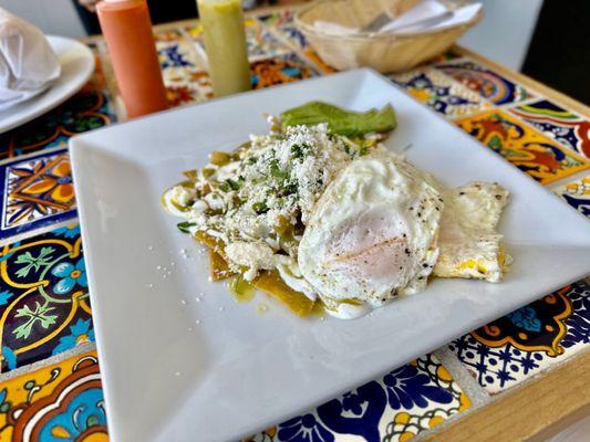 Salsa Verde Chilaquiles with Eggs - lightly fried corn tortillas, topped with spicy salsa verde, cotija cheese, and eggs