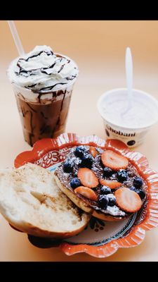 Nutella bagel, with fruit toppings, a chocolate frappé, with a blueberry yogurt.