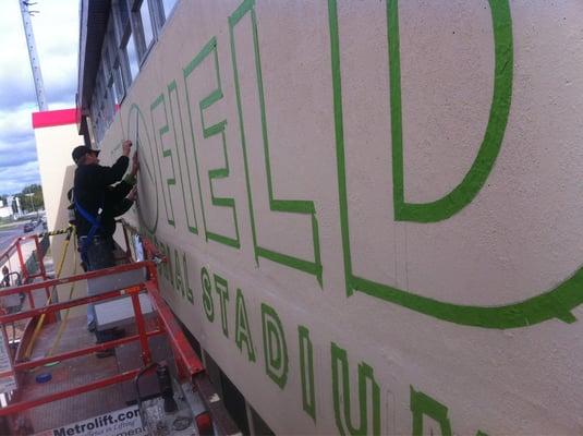 Stenciling the facade of ATI stadium in Joliet.