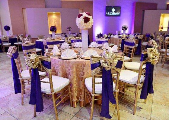 wedding table design plus tall vase round silk flower centerpiece. the vase contains led coloring that changes colors