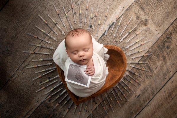 IVF baby holding his embryo photograph during his newborn session