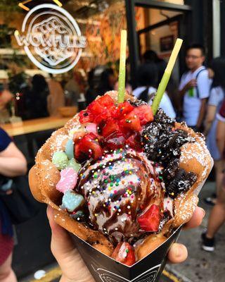 Coconut waffle with cookies and cream ice cream, topped with mochi, Oreos, strawberries, and chocolate drizzle