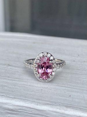 Custom designed oval lotus garnet and diamond halo ring