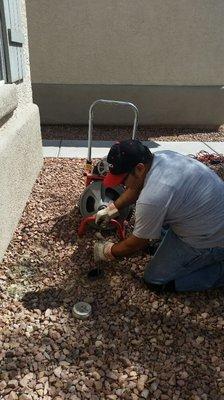 Unclogging a main drain with snake.