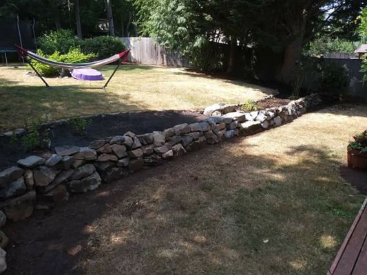 Rock retaining garden wall, half is with soil especially for herbs & vegetables and the other half is designed for flowers.