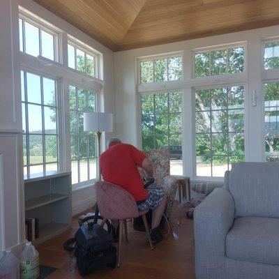 Timothy Hoffman owner working hard cleaning a chair.