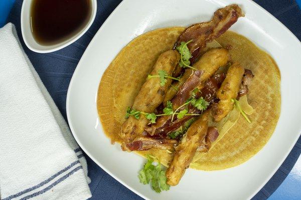 Affirmation. Battered chicken strips and candied maple bacon, atop Belgian waffle tortilla, w/ maple syrup and dusted with powered sugar.