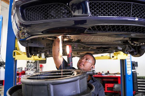 Master Tech Jesse Tang draining oil on a W12 Bentley engine.