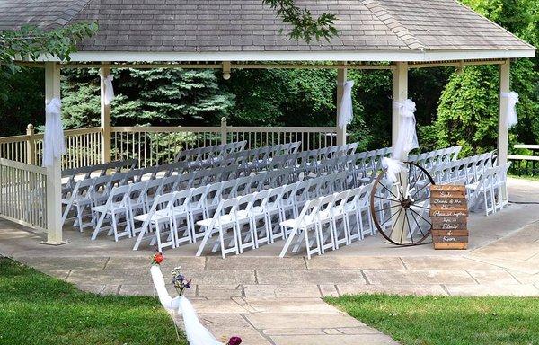 Wedding chairs under a shelter for a ceremony.