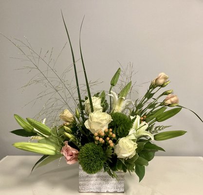 Organically arranged premium flowers in peach and white.