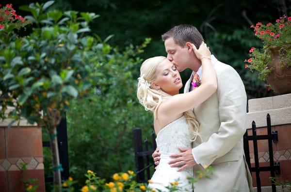 Passionate bride and groom sharing a moment right before heading to the reception.