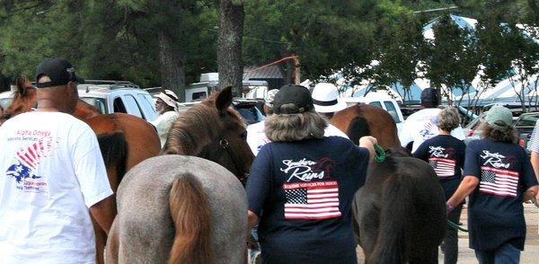 Clients of Alpha Omega Veterans Services leading horses at the Germantown Charity Horse Show with Southern Reins Center for Equine Therapy