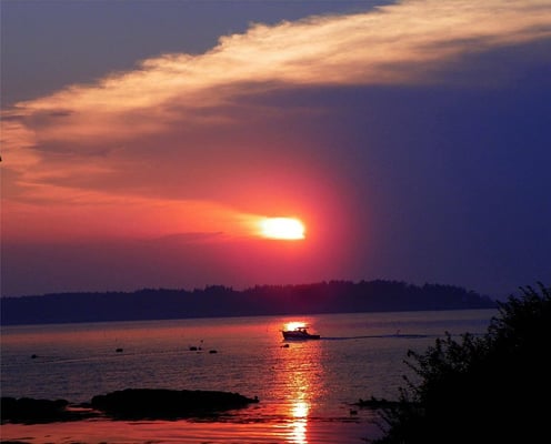 A lobster boat heading in at dusk.