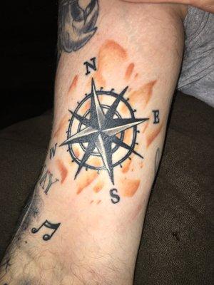 Upper right arm nautical compass.