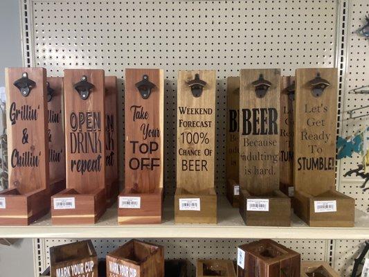 Beer or soda bottle openers with sayings and bottle cap disposal area.