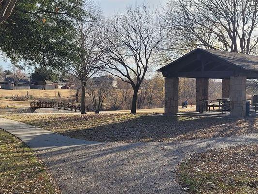 Covered picnic table with path to blue trail and bridge to 2 small nature area