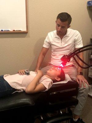 Dr. Ernesto providing red laser therapy immediately after a concussion.