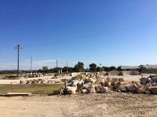 The front yard has a large variety of stones, rocks, and soils.