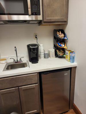 Coffee and water are available to guests in a kitchenette area.