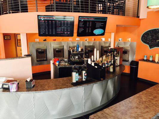 The counter boasts digital menus, a full espresso bar, friendly baristas, and self-serve coffee brewed fresh daily.