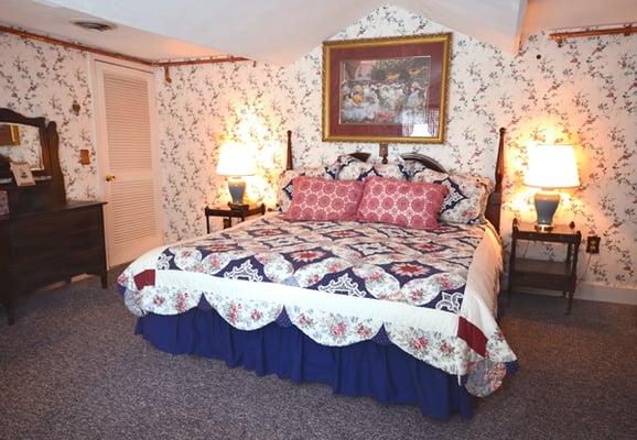 The Rosemary Room room is a large carpeted room with a king-size bed, pool view, and a large bathroom with a tub/shower combo.