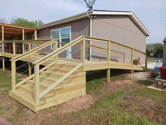 Custom deck with wire rope handrails, wheelchair ramp, and polycarbonate roof system.