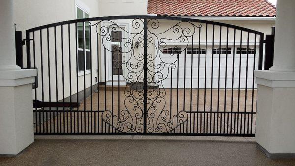 Driveway gate. Green and Son design called Angels Arch. Powder coated black with a Lift Master LA 500 swing gate operator. Frisco, Texas.