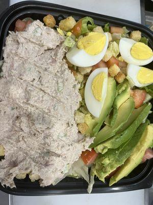 A refreshing salad over tuna fish avocado and boiled eggs