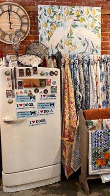 Beautiful scarves next to magnets & stickers on old fridge