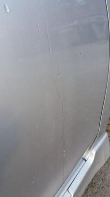 Sides of car covered in dirty water spots