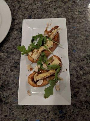 Smoked brie bruschetta with almonds, arugula, and a balsamic glaze.