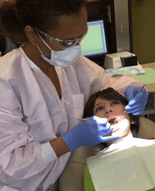 Dr. Ifechide Nwabueze, DMD performing dental exam