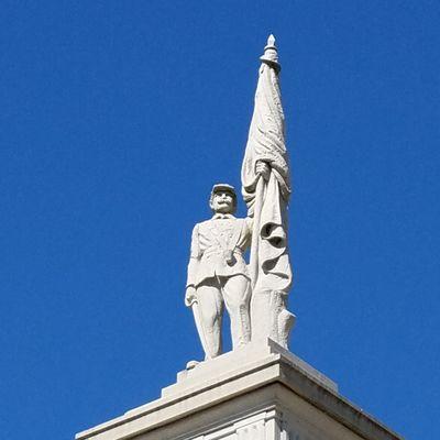 Flag bearer rests on top of the monument