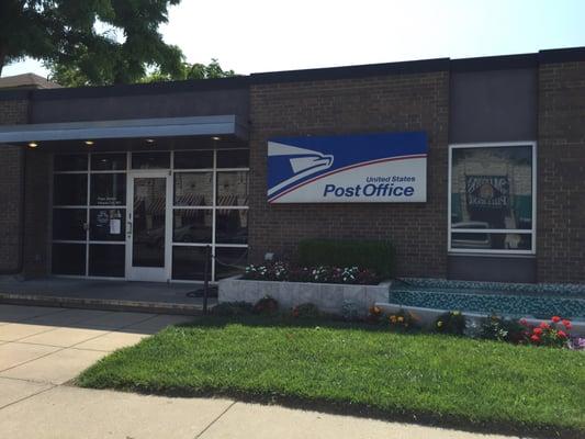 Front of the post office. Flowers and a fountain.