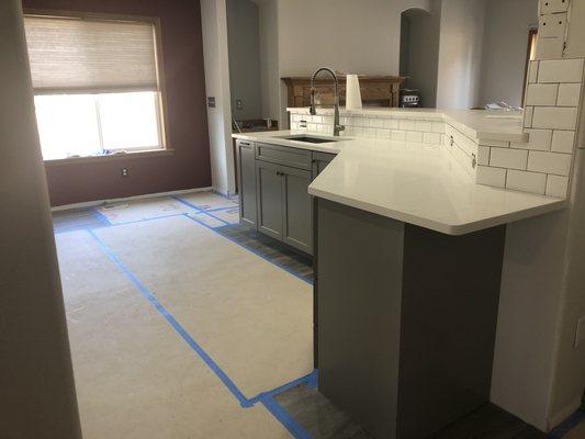 New layout of kitchen with new cabinets, countertop and backsplash