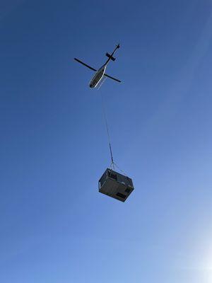 Using a helicopter to fly in a new packaged system heat pump.