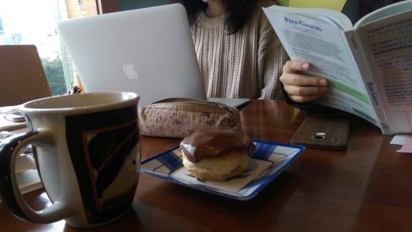 Studying with a cup of coffee and donut.